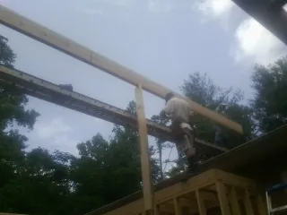 Carpenter setting a ridge beam over a new addition frame — Ice Dam Removal by Roofing Brothers in Fishertown